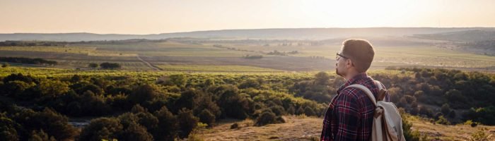 a-man-standing-on-a-mountain-as-the-sun-sets-2023-11-27-05-15-05-utc_Easy-Resize.com